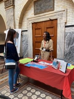 A student in a black top stopping by the Frame Your Degree book table